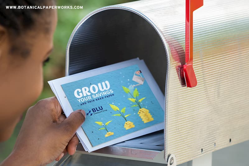 A girl putting a seed paper card in a mailbox
